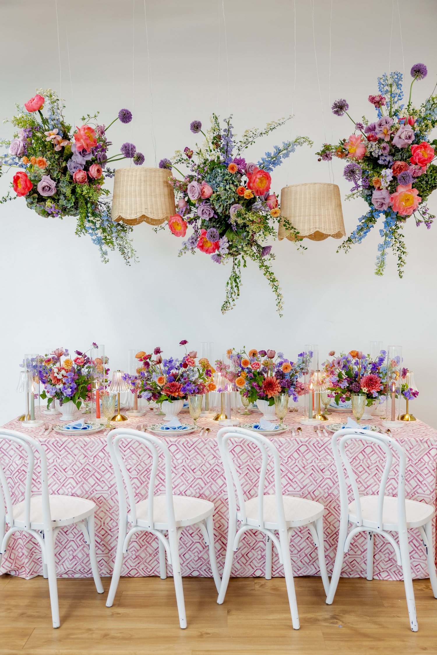 Suspended floral installation above vibrant centerpieces