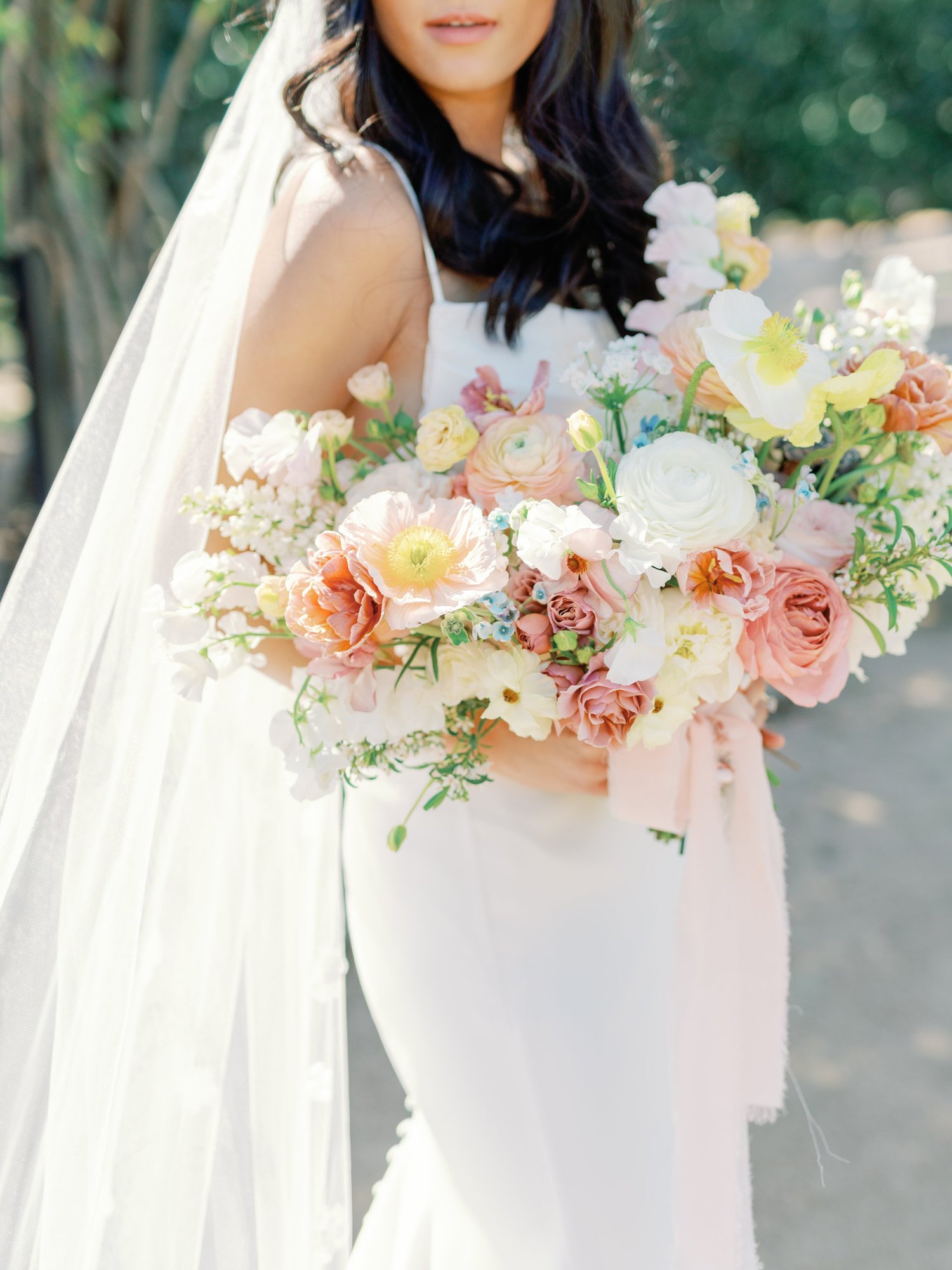 Bride holding a soft pastel garden bouquet
