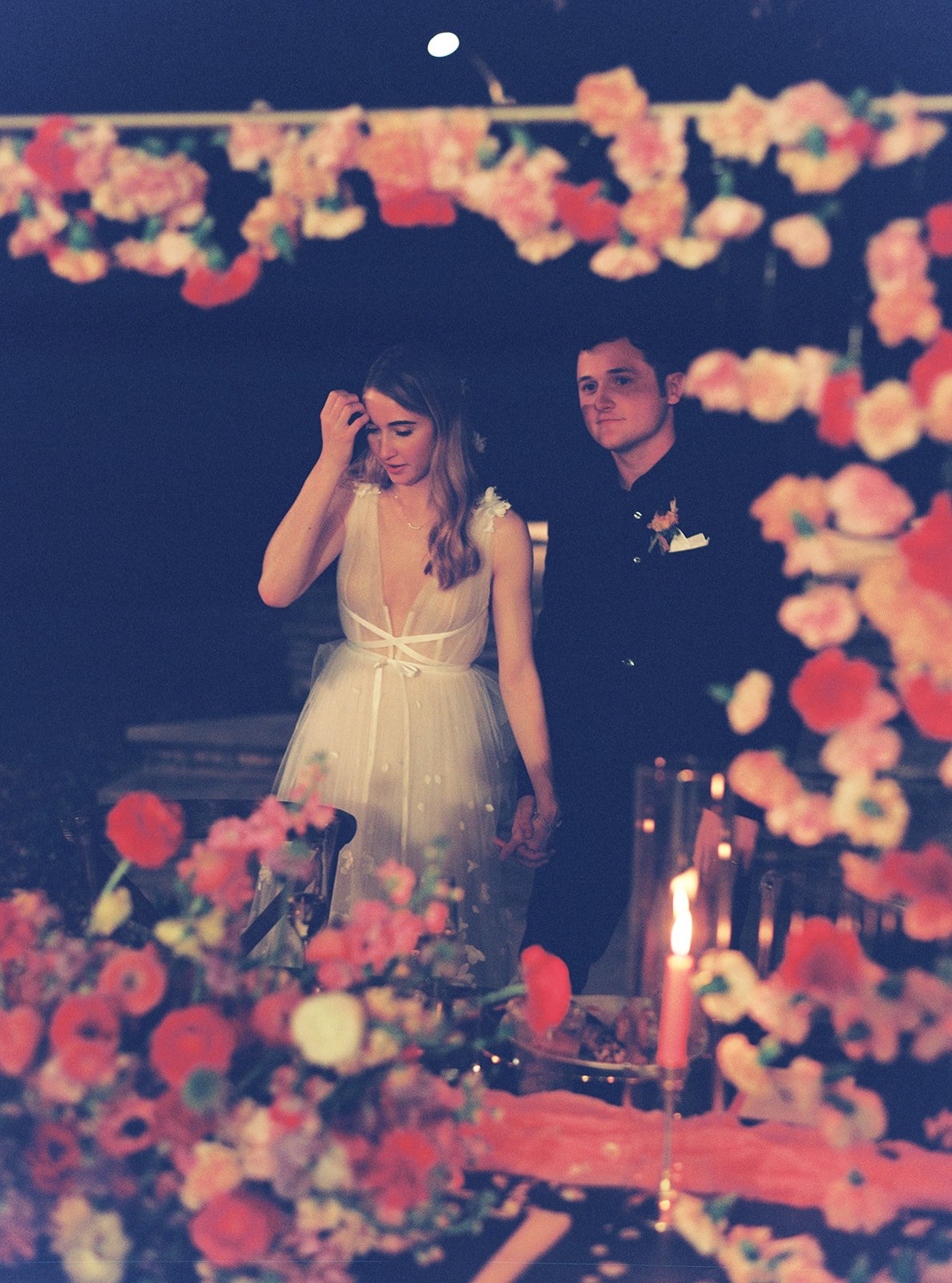 Couple framed by a suspended garden of blooms