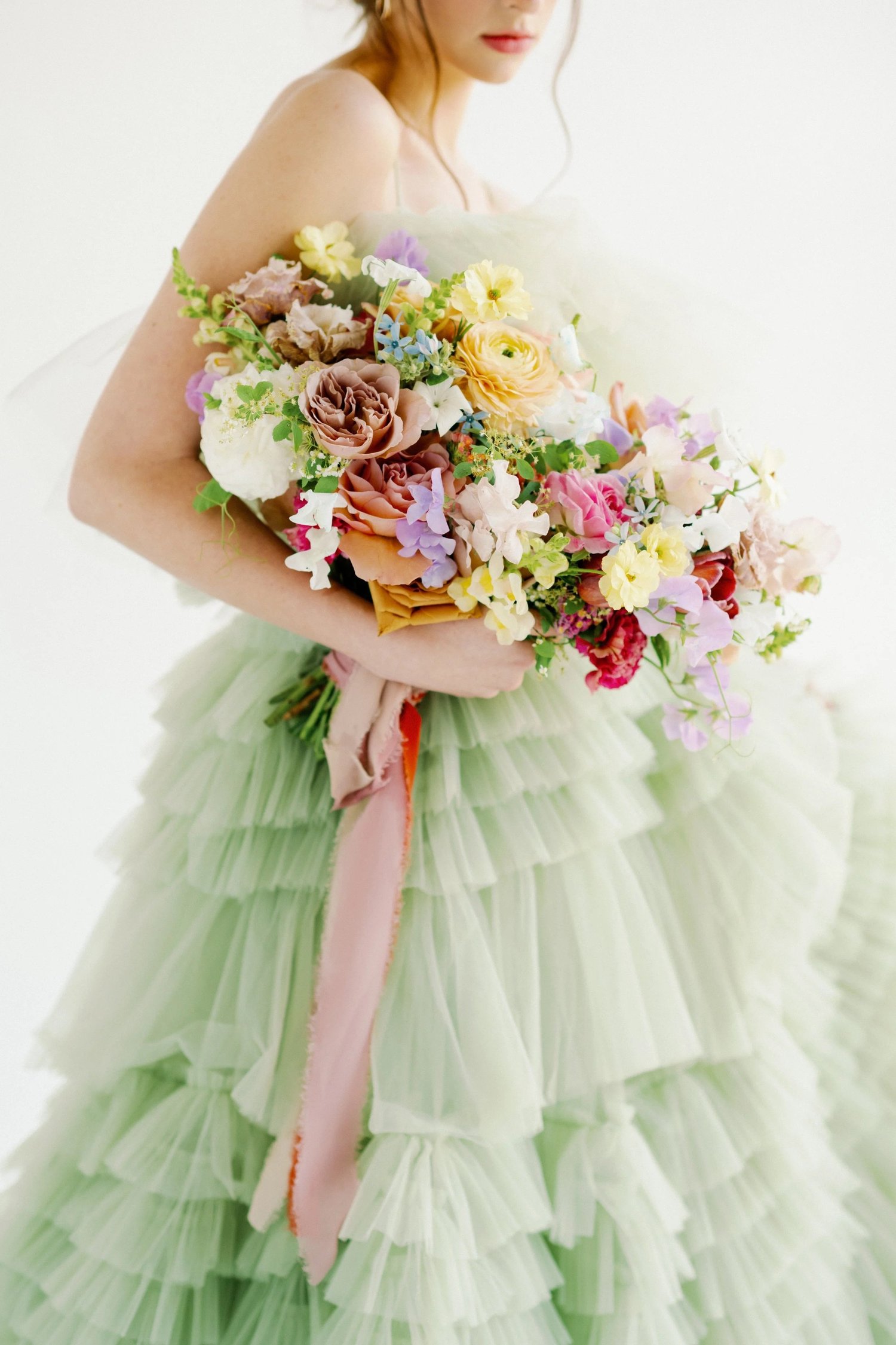 Whimsical color-filled bridal bouquet with trailing ribbon