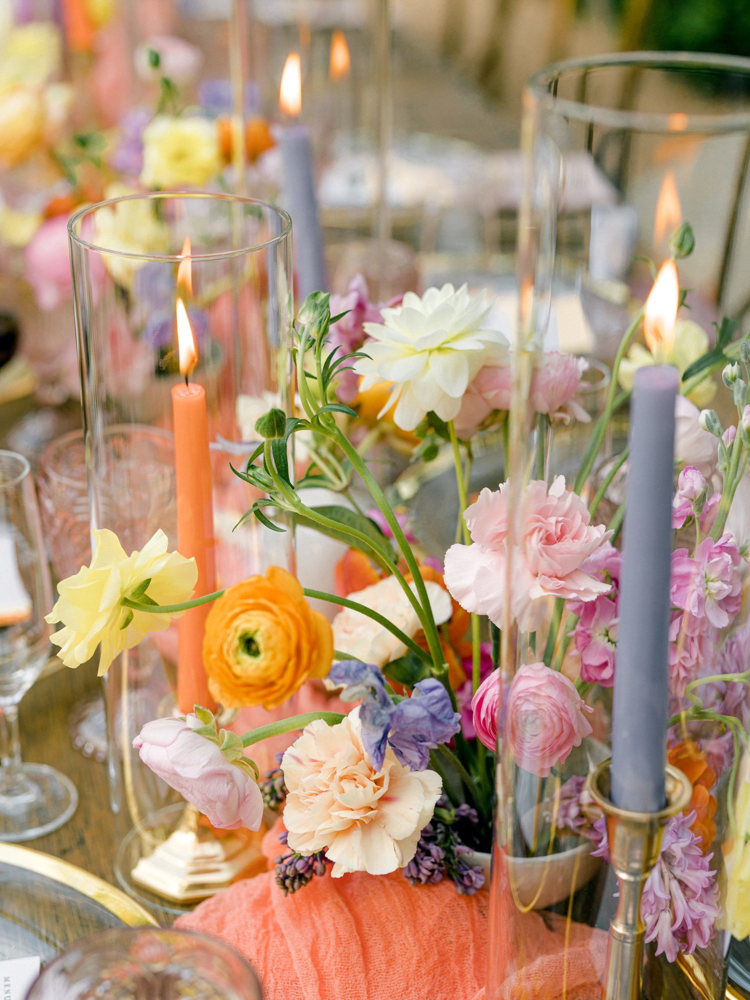 Colorful candlelit centerpiece detail with ranunculus and roses